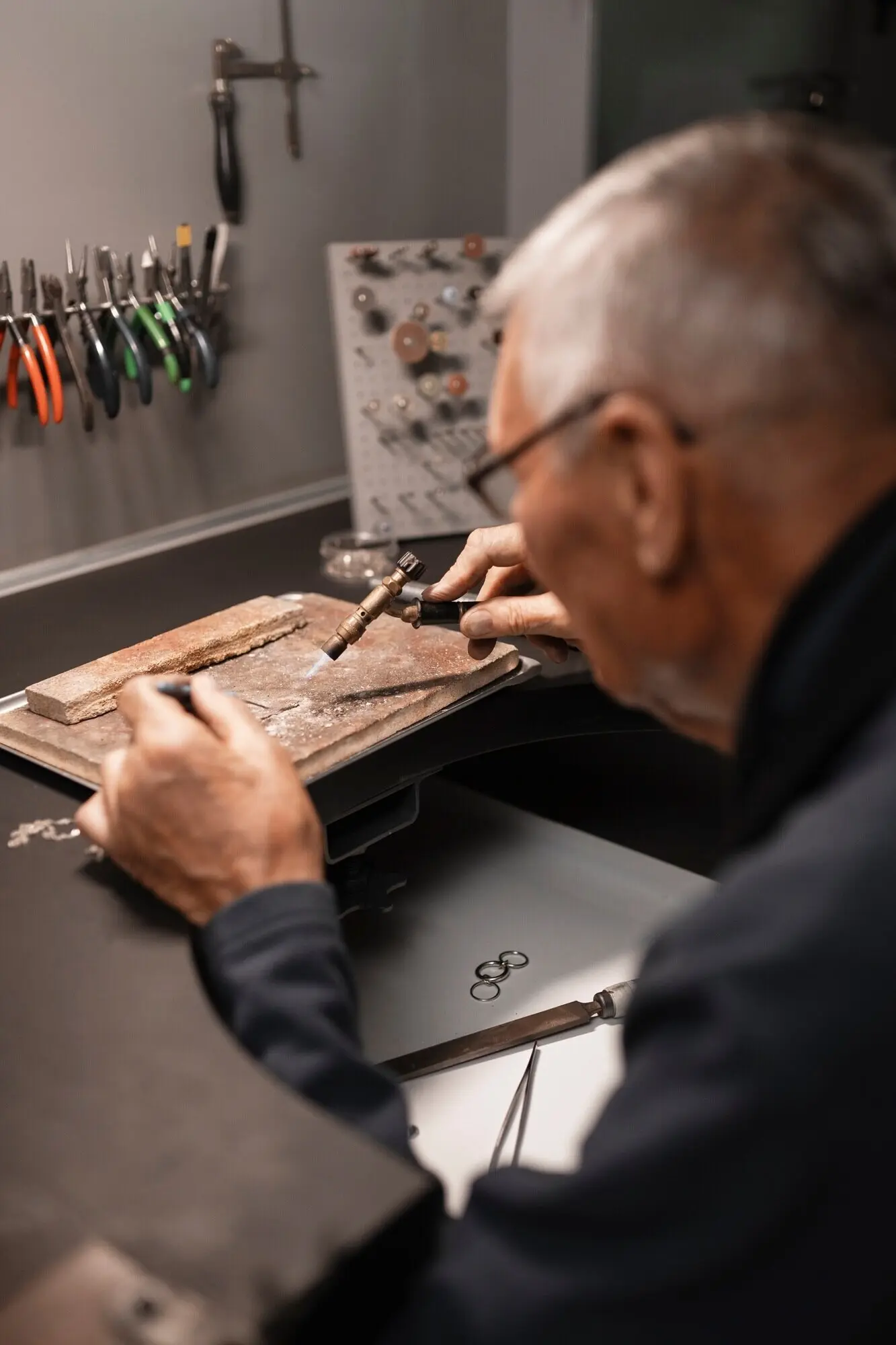 A male jeweler at work in the shop.
